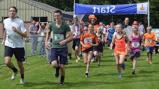 Jonge mensen die over de finish lijn van een hardloopwedstrijd rennen